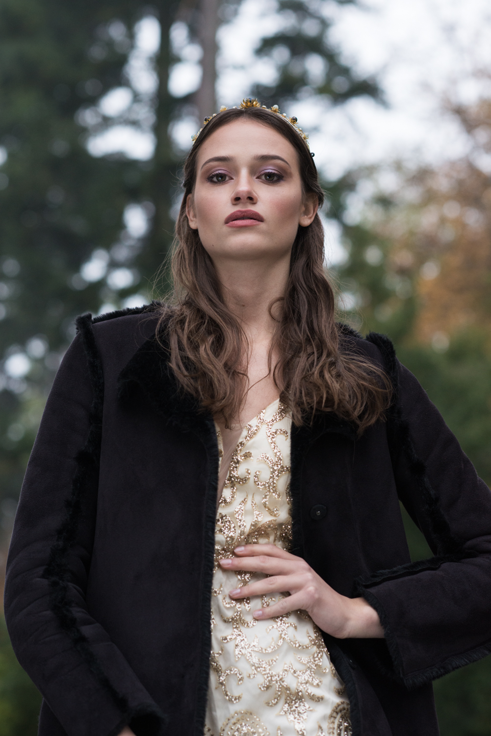 woman in golden dress wearing black coat at her villa